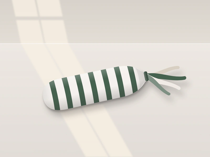 Illustration: a long striped fabric kicker toy lying on the floor, with fabric ribbons sewn into one end